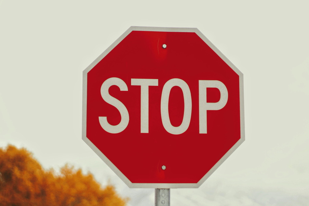 Close up of a red and shite stop sign on a road